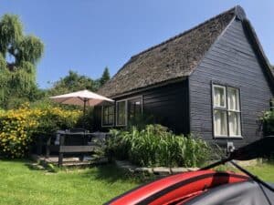 Vakantiehuisje Giethoorn Lodge met terras en kano bij de hand.